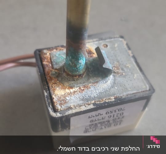 חלק מתכתי עם חלודה וקורוזיה על משטח אפור